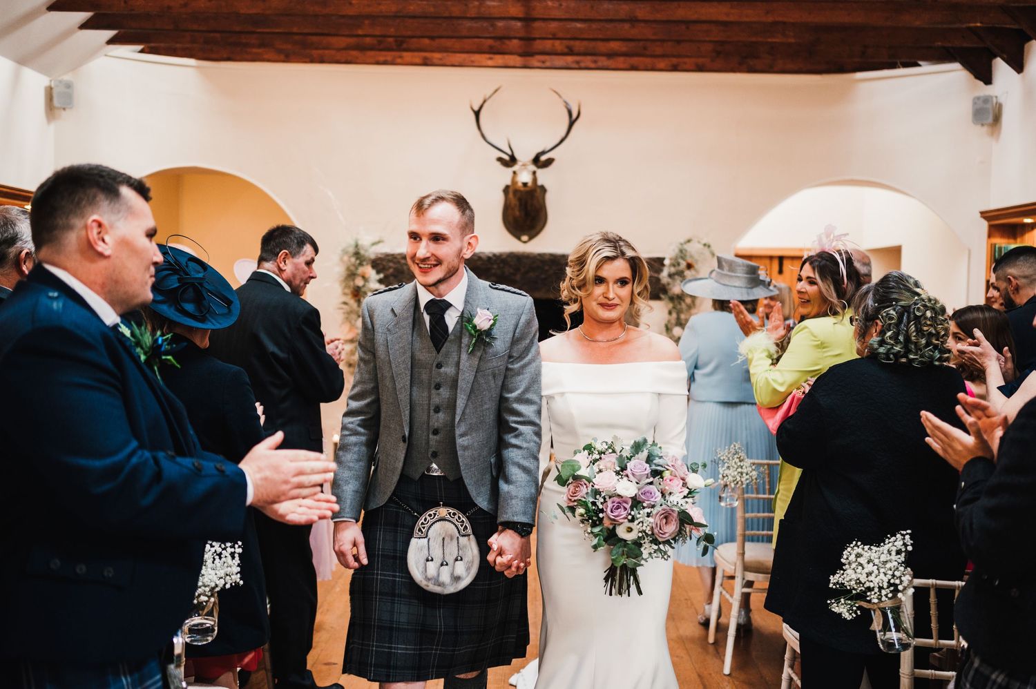 Elegant wedding reception venue with wooden beams and warm lighting creates an intimate atmosphere.