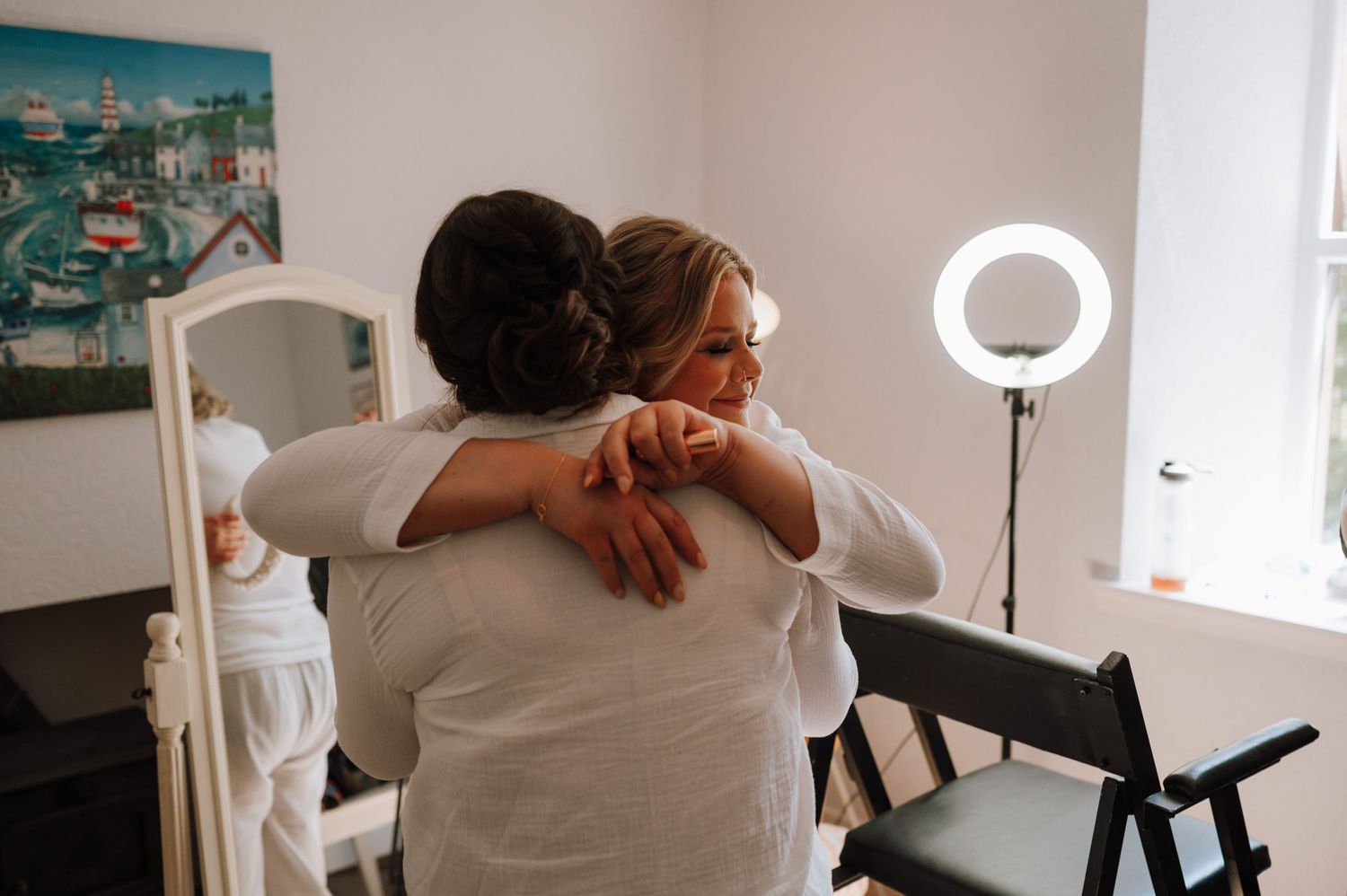 An emotional embrace captured in front of a vanity with a ring light.