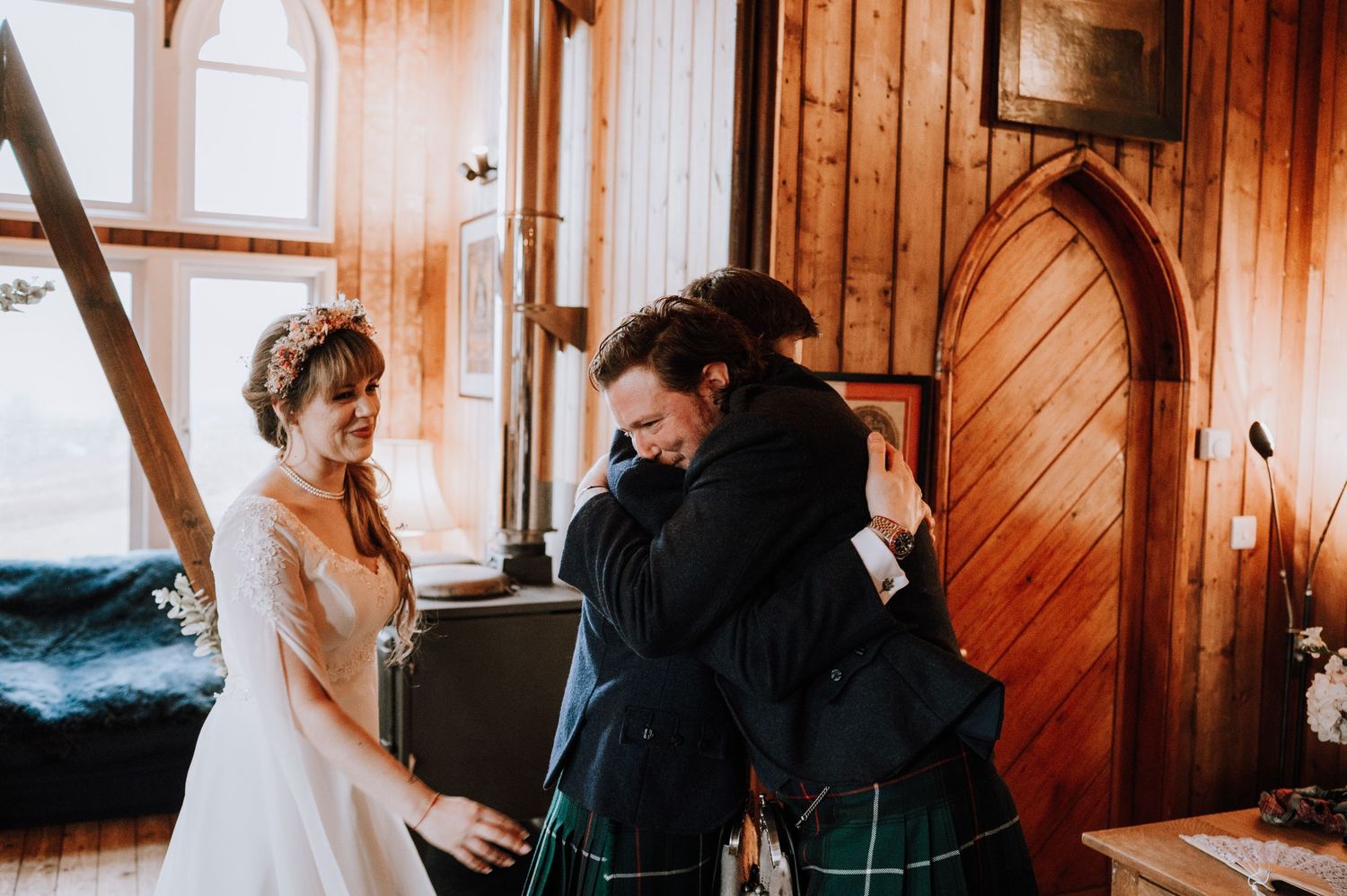 Emotional moment shared between wedding couple in Scottish attire at rustic venue.