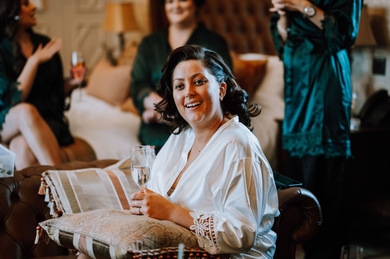 Wedding preparation scene with someone in white robe holding a gift while others gather around.