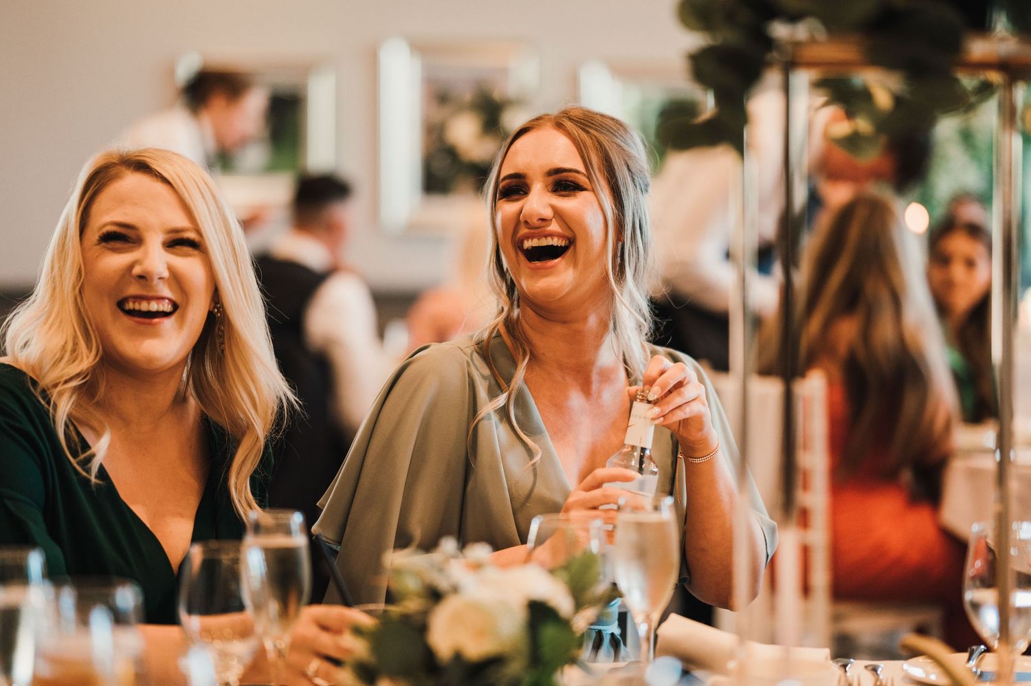 Candid moment of guests laughing and enjoying themselves at a wedding reception.