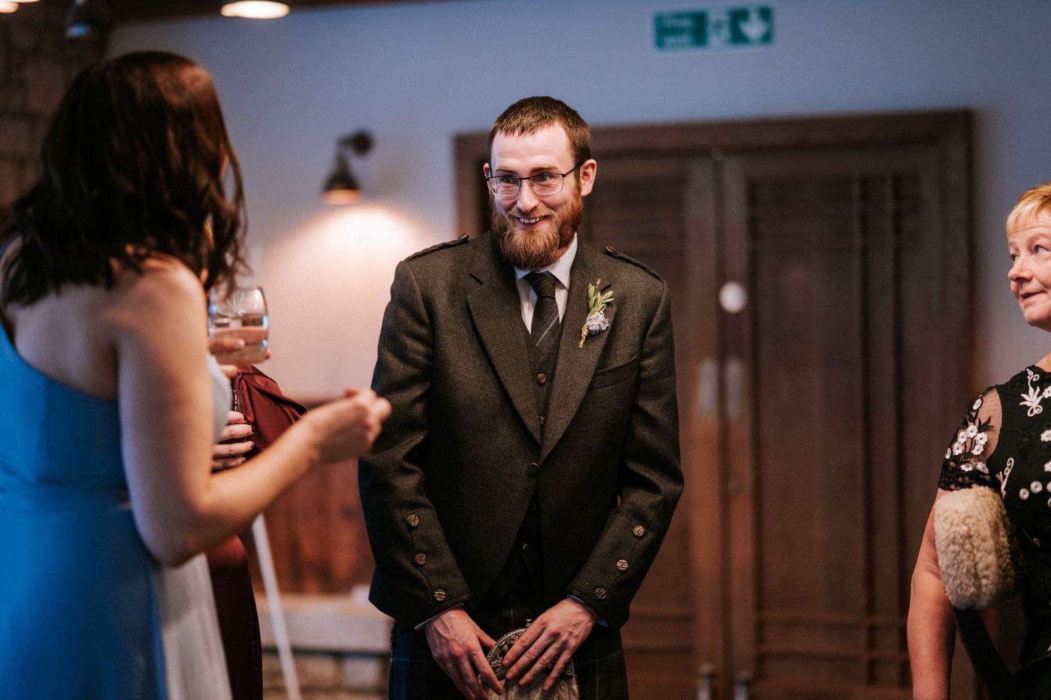 Indoor wedding reception venue with warm lighting and elegant formal attire.