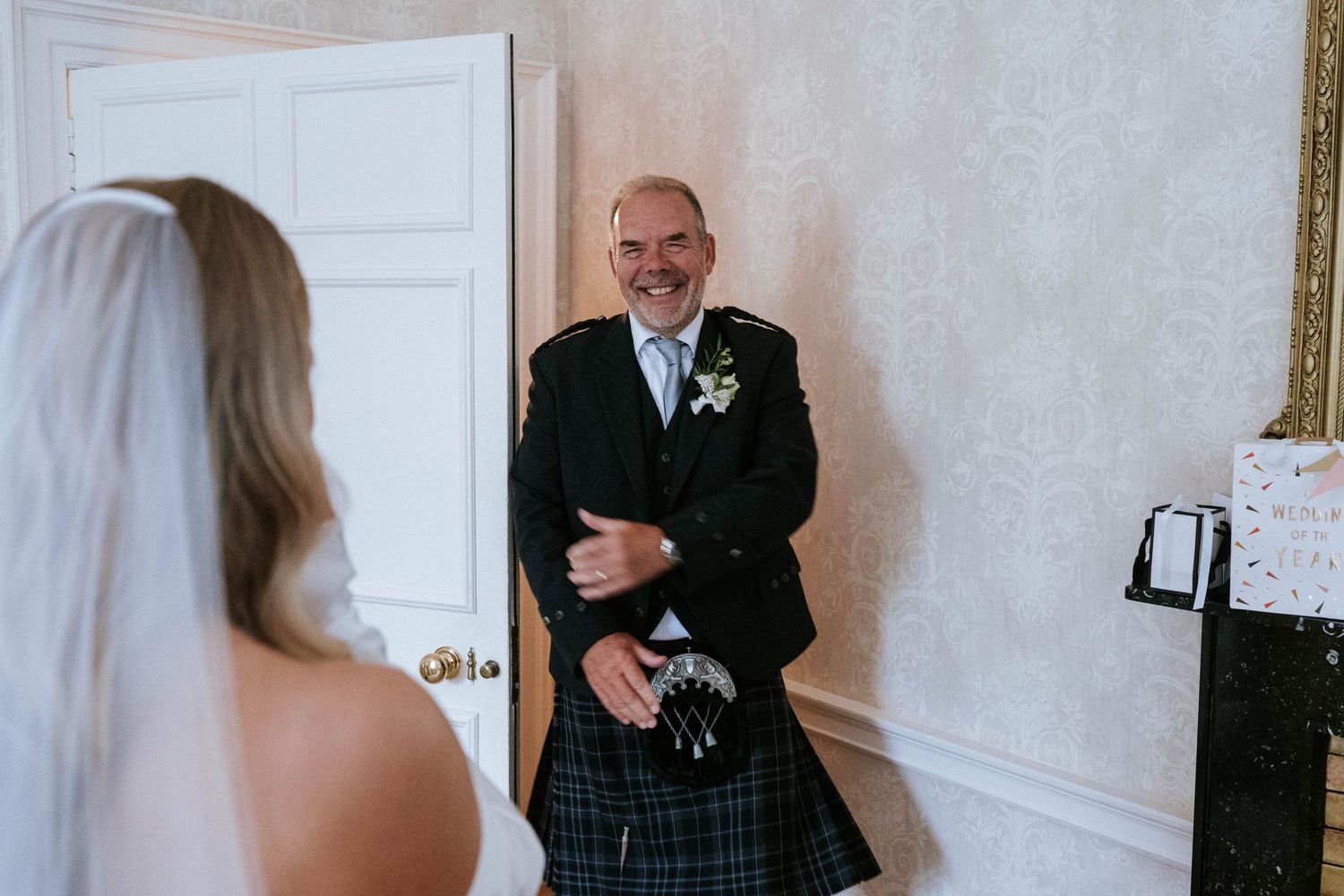 Emotional first look reactions during a wedding day in an indoor setting.