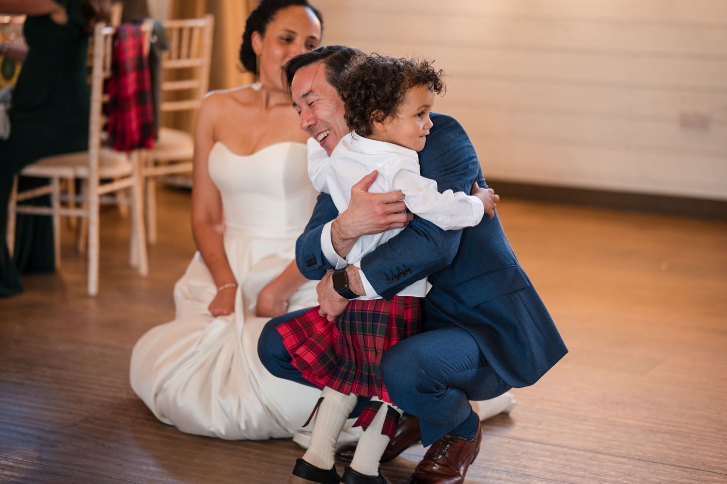 Couple dancing together on a wooden floor during their wedding reception.