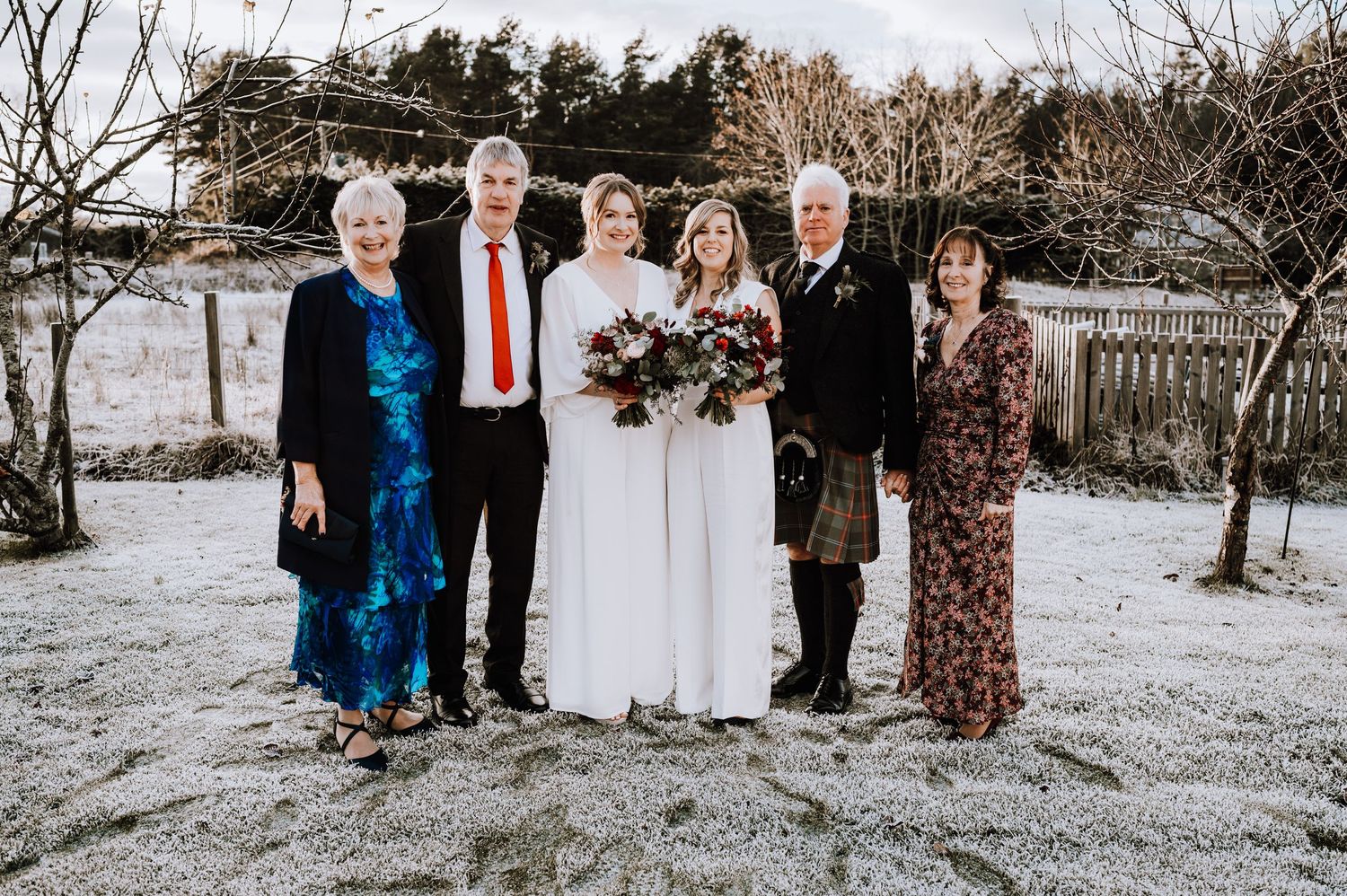 Same Sex Wedding Photography. Wedding group photo with family members in formal attire on snowy winter day.