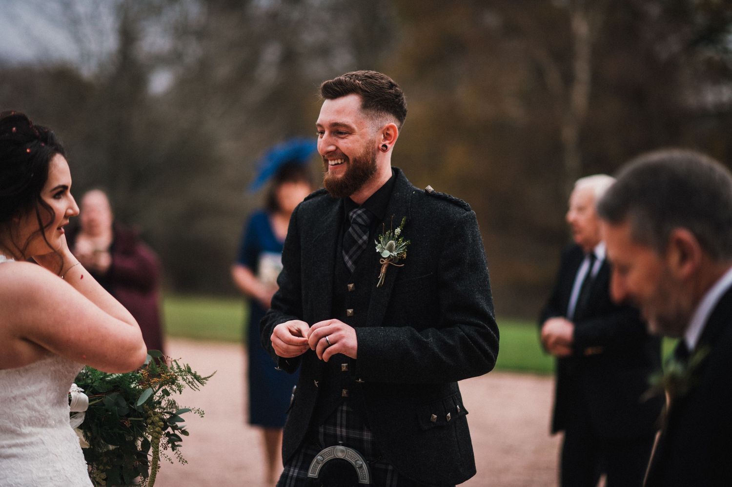 Candid moment between wedding couple during outdoor Scottish ceremony.