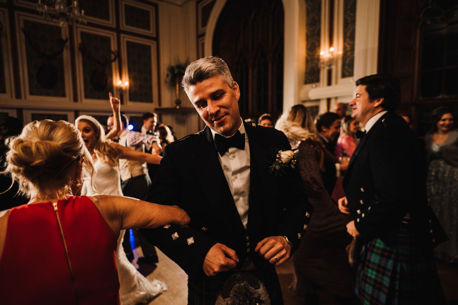 Formal reception dance with guests in traditional Scottish attire enjoying the celebration.