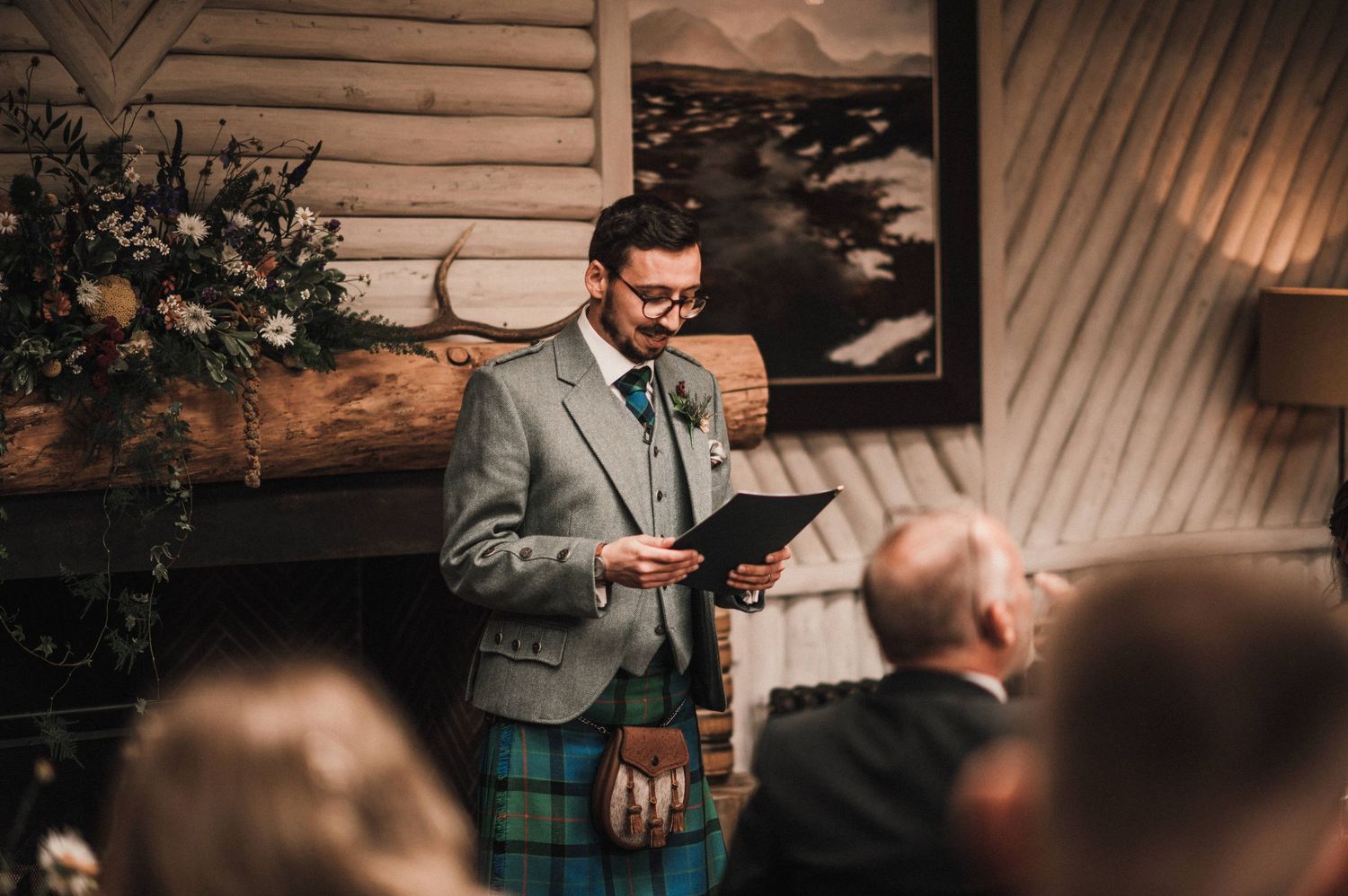 Guest delivering speech at formal Scottish event with traditional attire.