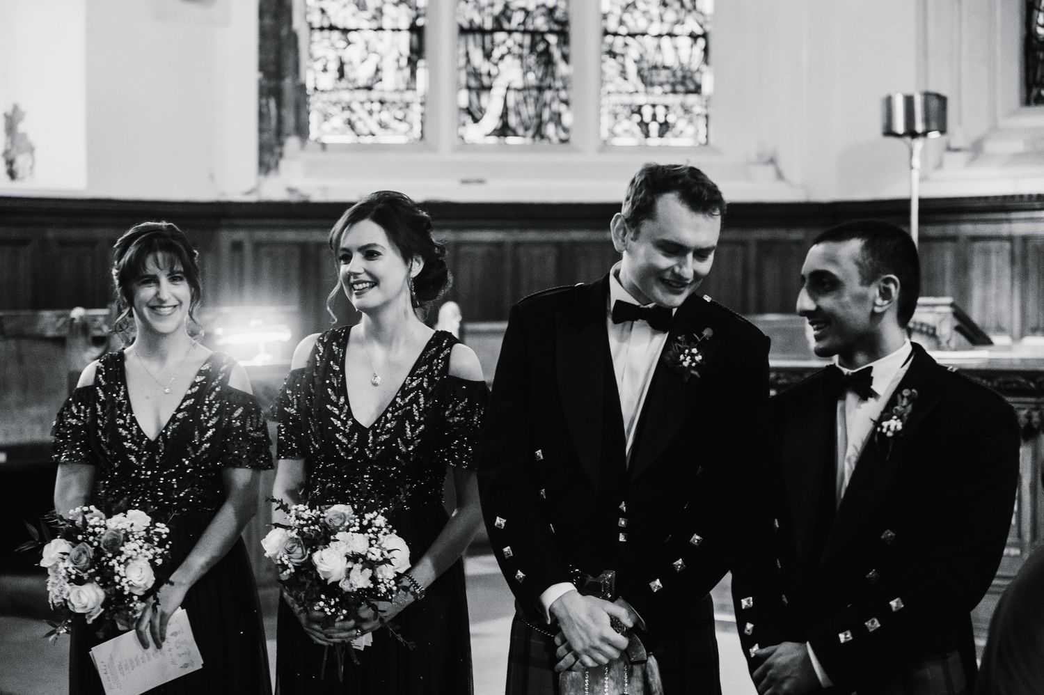 Black and white photo of wedding party in formal attire with Scottish kilts.