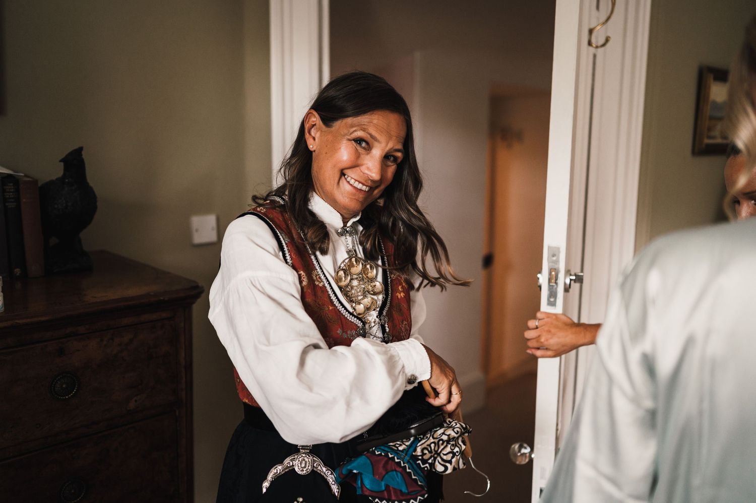 Candid moment captured during wedding preparations showing joyful laughter and movement.