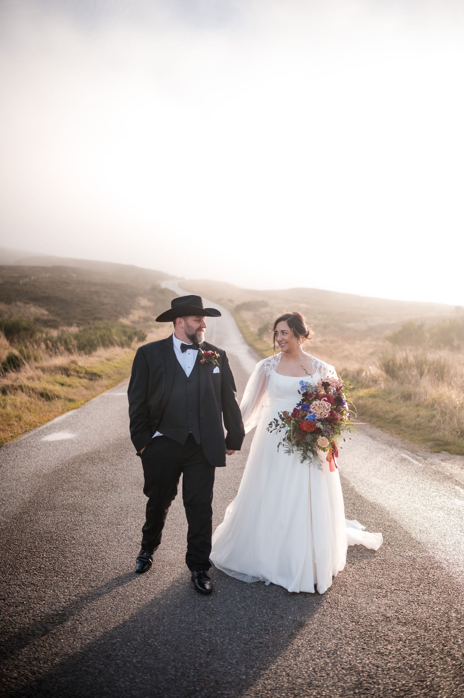 Aberdeen Wedding Photography. A couple strolls down a winding country road during their wedding celebration.