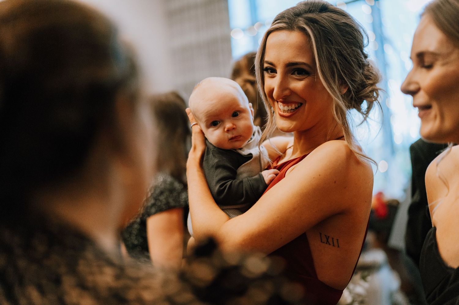 A tender moment between guests and a baby at a wedding celebration.