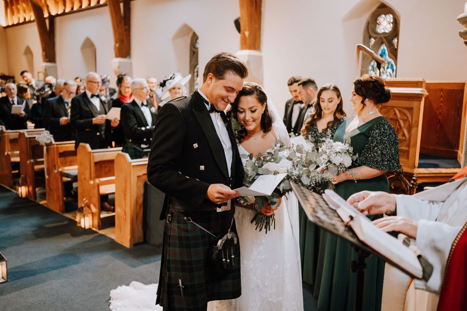 A Scottish wedding ceremony in a church with the groom wearing a traditional kilt.