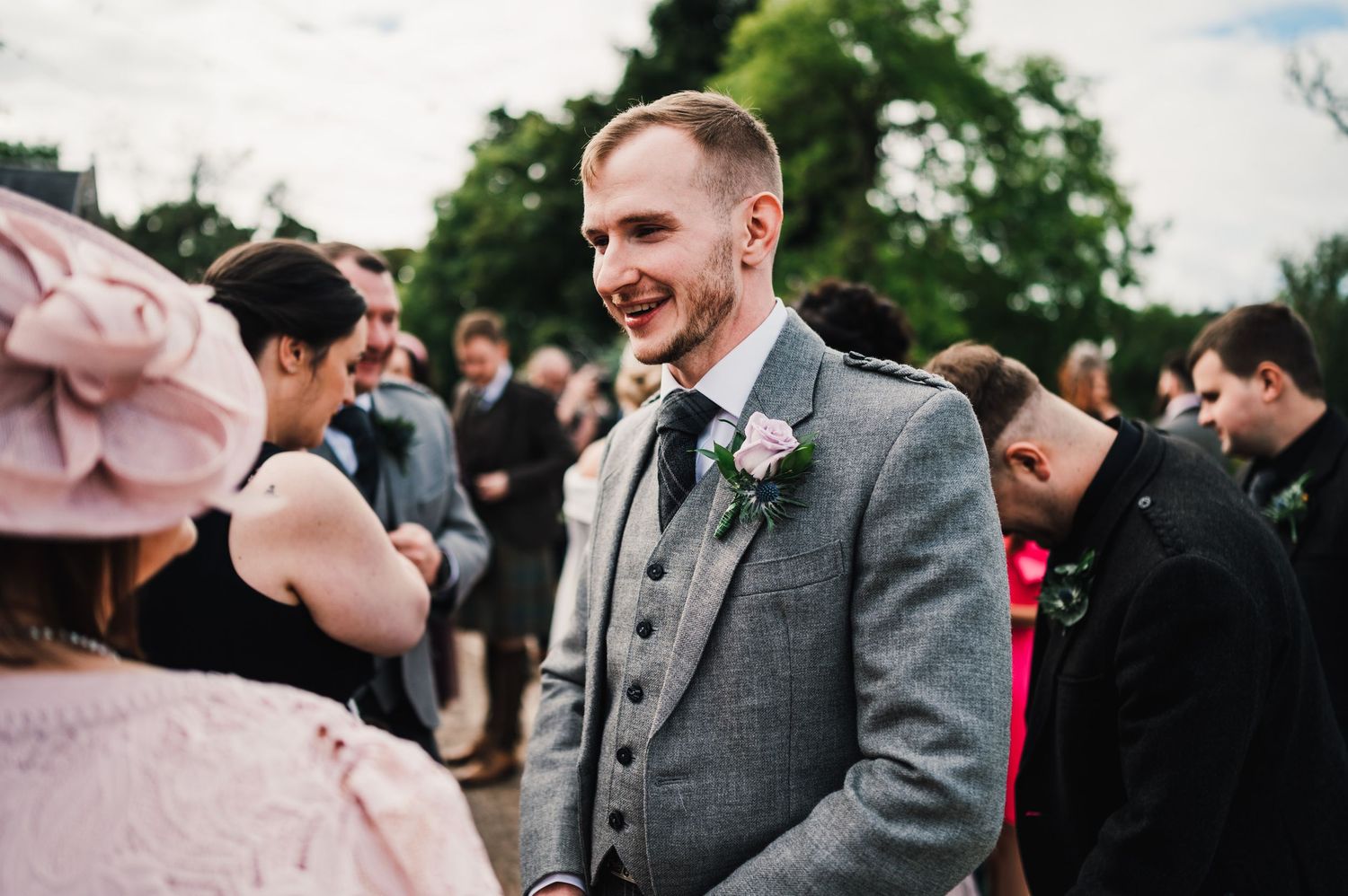 Candid moments from a wedding celebration with guests in grey and pink formal wear.