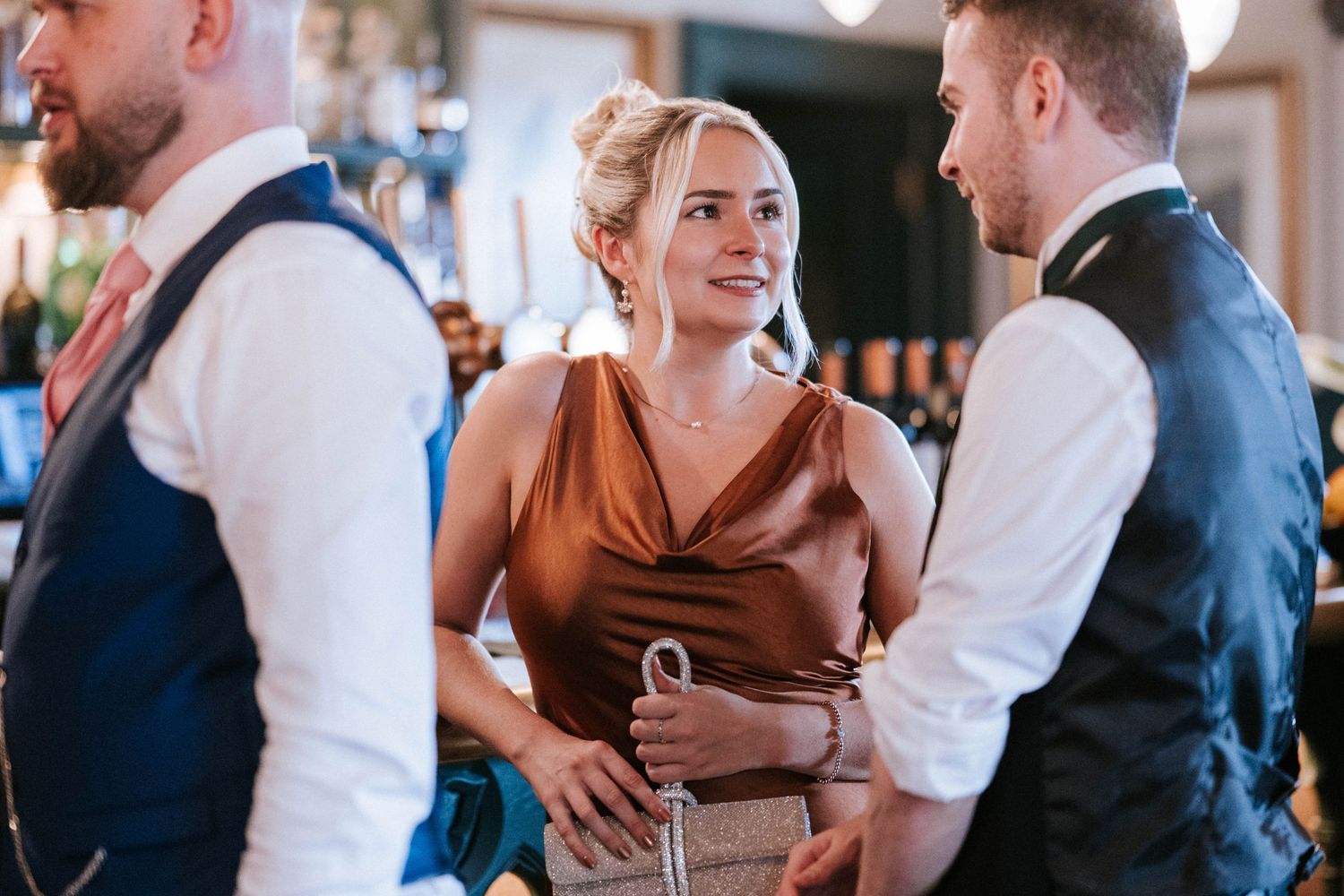 Guests mingling and dancing at an elegant indoor wedding reception.