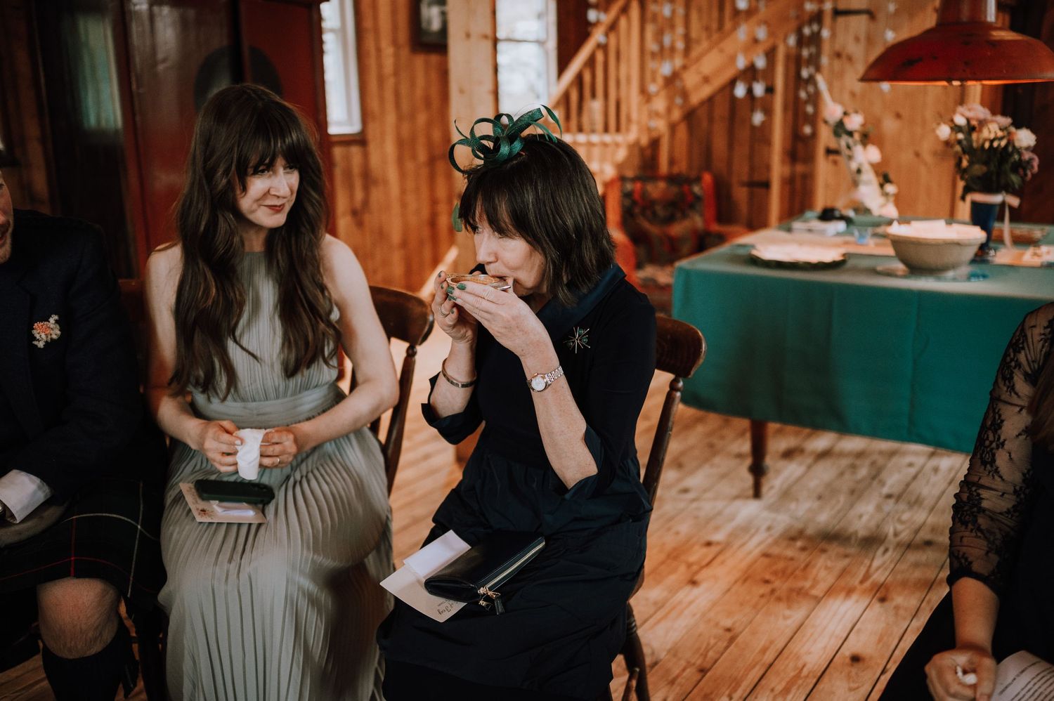 People having an emotional reaction while seated in a wooden-paneled room.