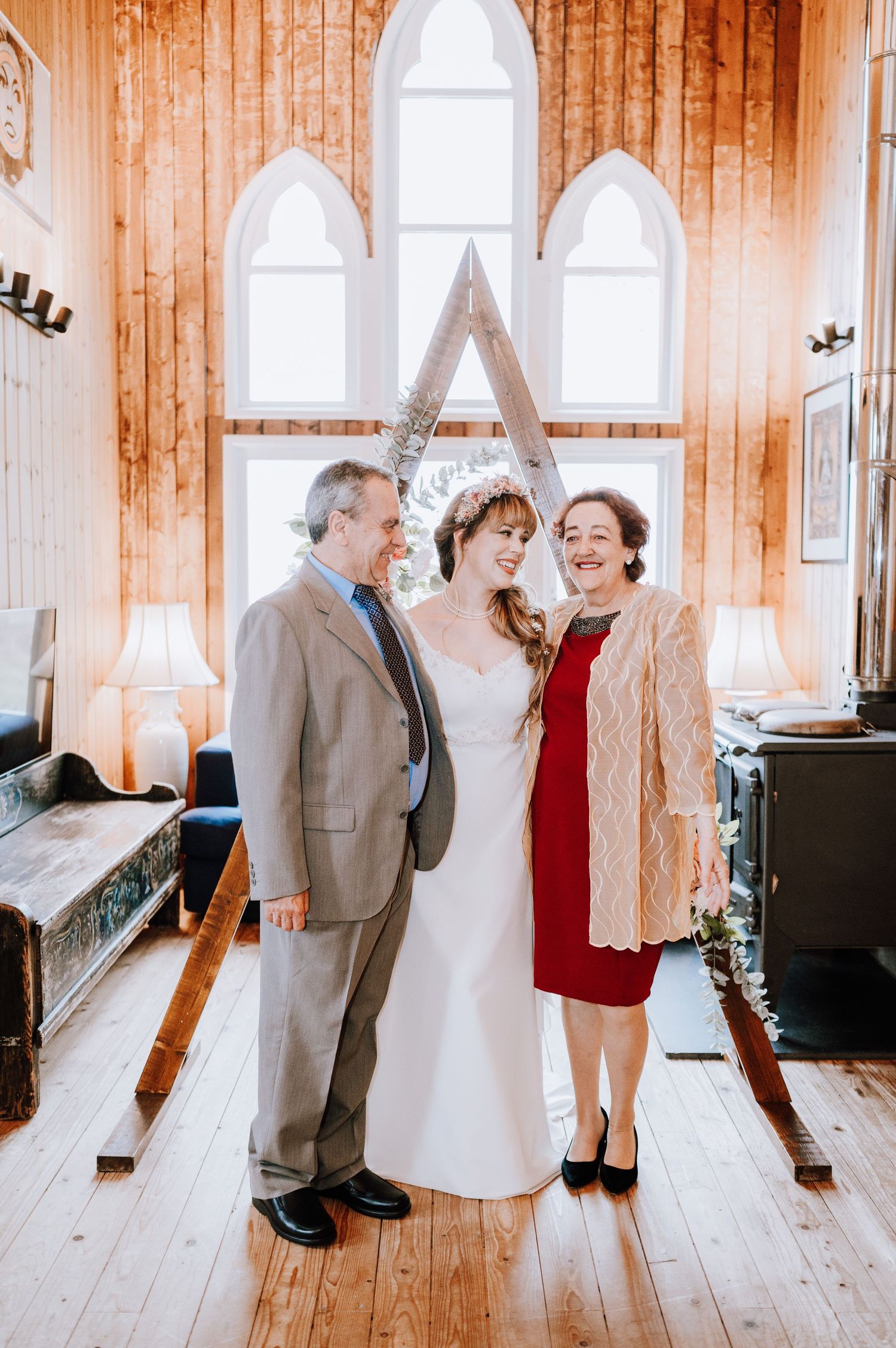 Rustic chapel interior with wooden walls and decorative A-frame wedding setup.