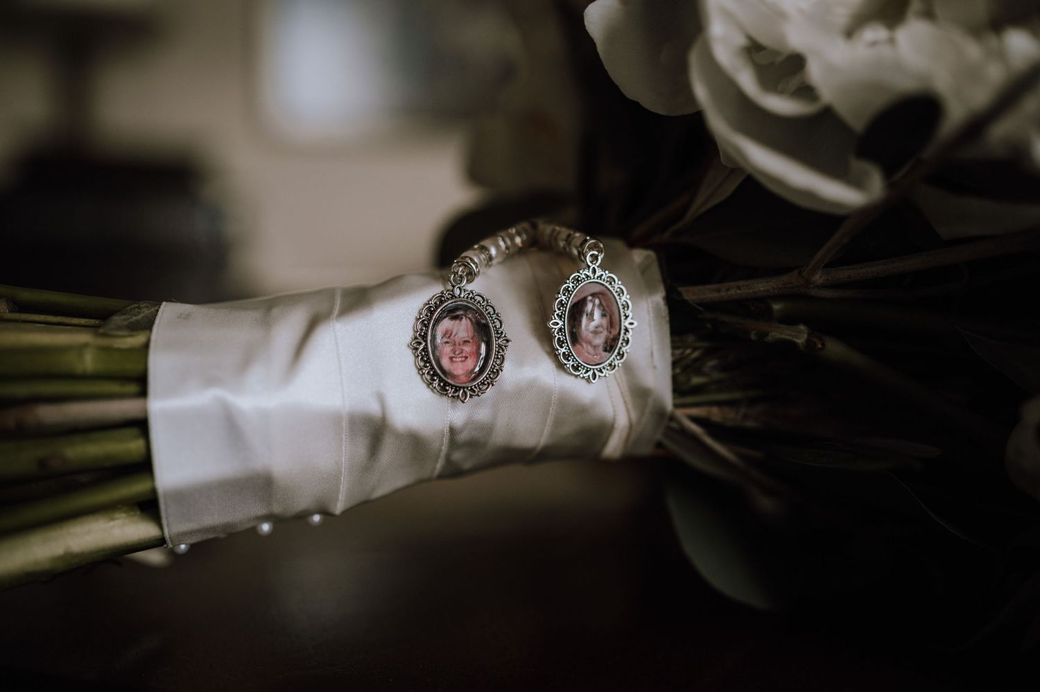 Two vintage-style cameo brooches pinned to white fabric with flowers.