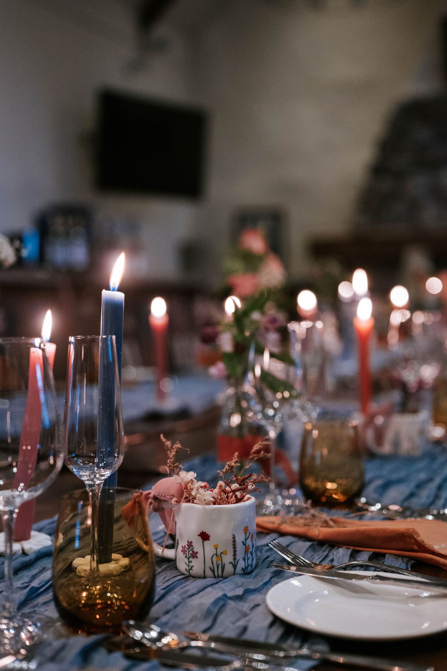 Elegant table setting with lit red candles and wine glasses creating a romantic dinner atmosphere.