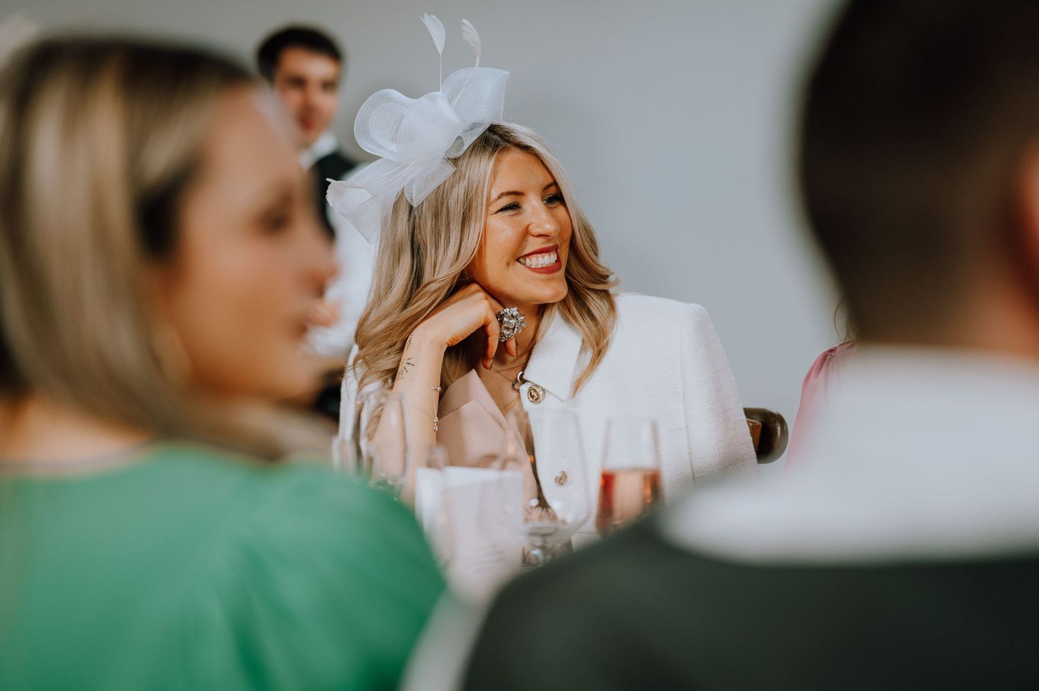 Wedding guests share smiles and conversation during an elegant indoor reception.