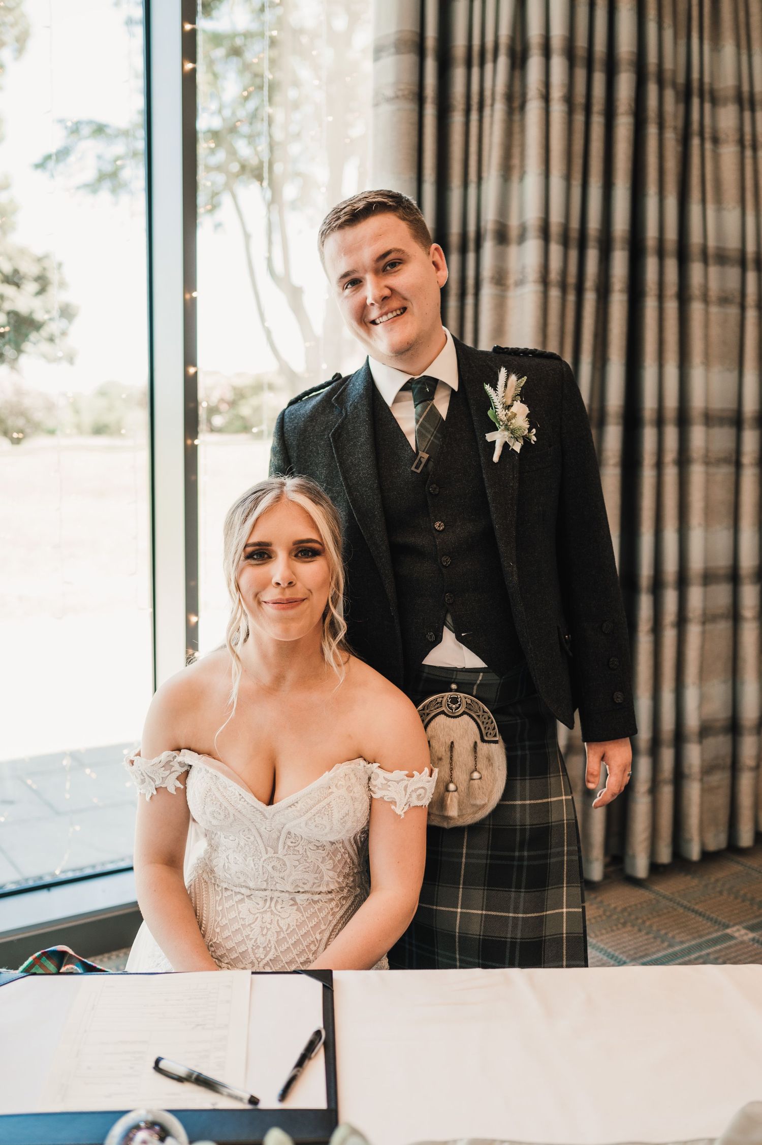 A Scottish-themed wedding featuring traditional formal wear and elegant decor at an indoor venue.