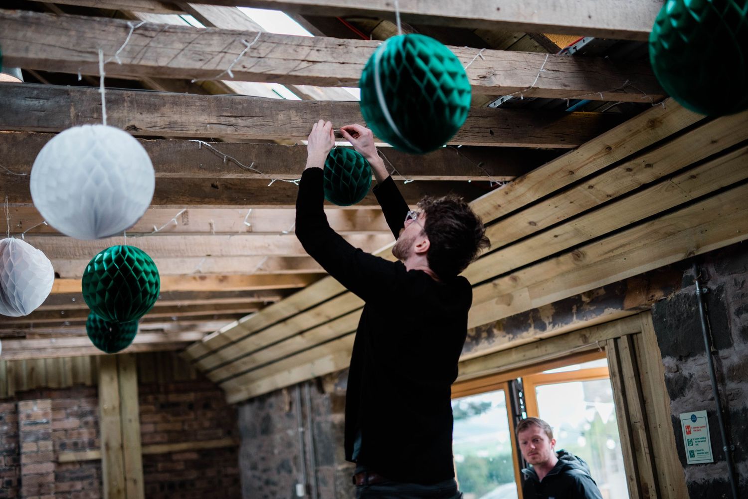 Figure decorating room with hanging paper lanterns in white and teal colors.
