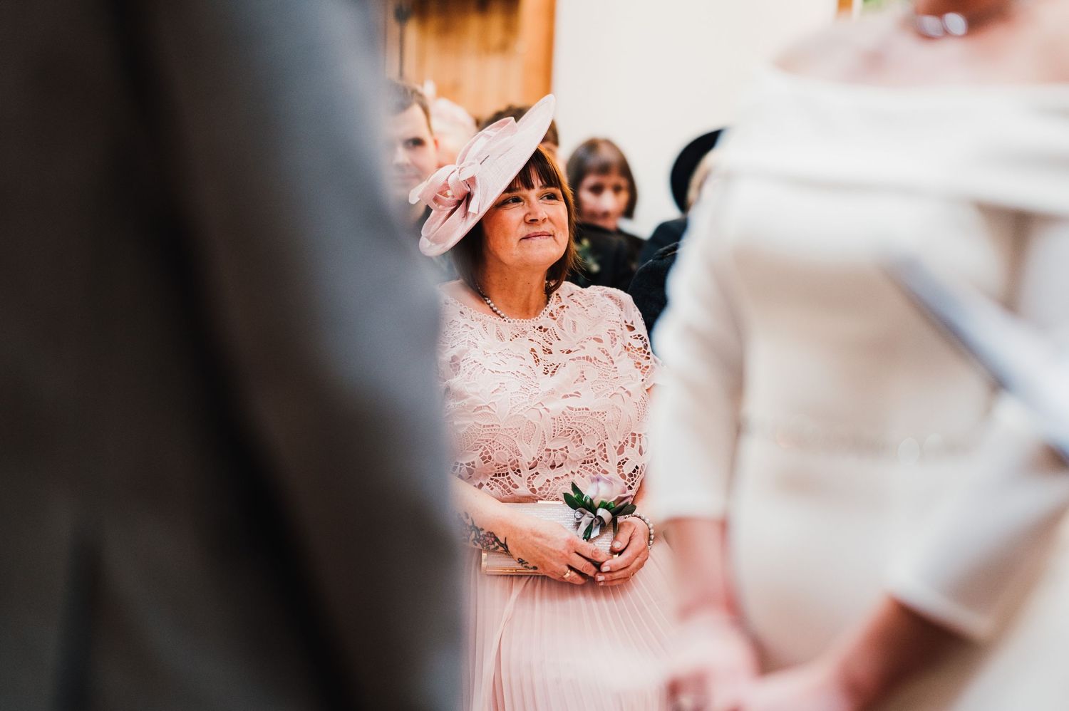 Guests smile and celebrate during an intimate indoor wedding ceremony.