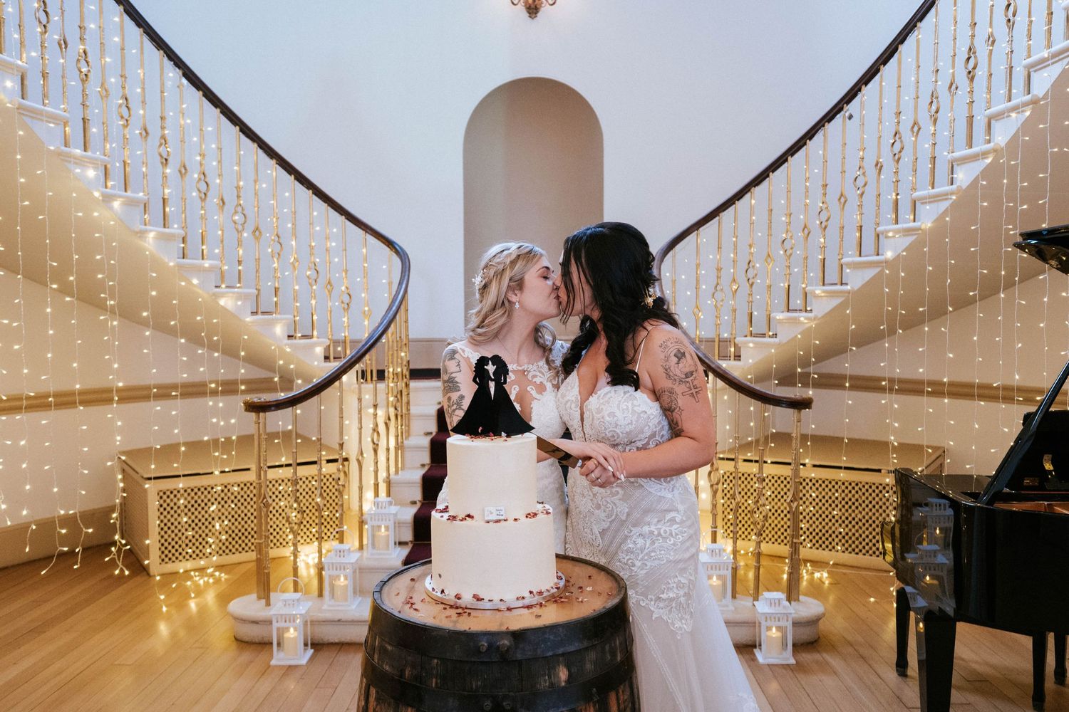 Fasque Castle Wedding PhotograA wedding reception venue decorated with hanging string lights and white fabric creates a romantic atmosphere.