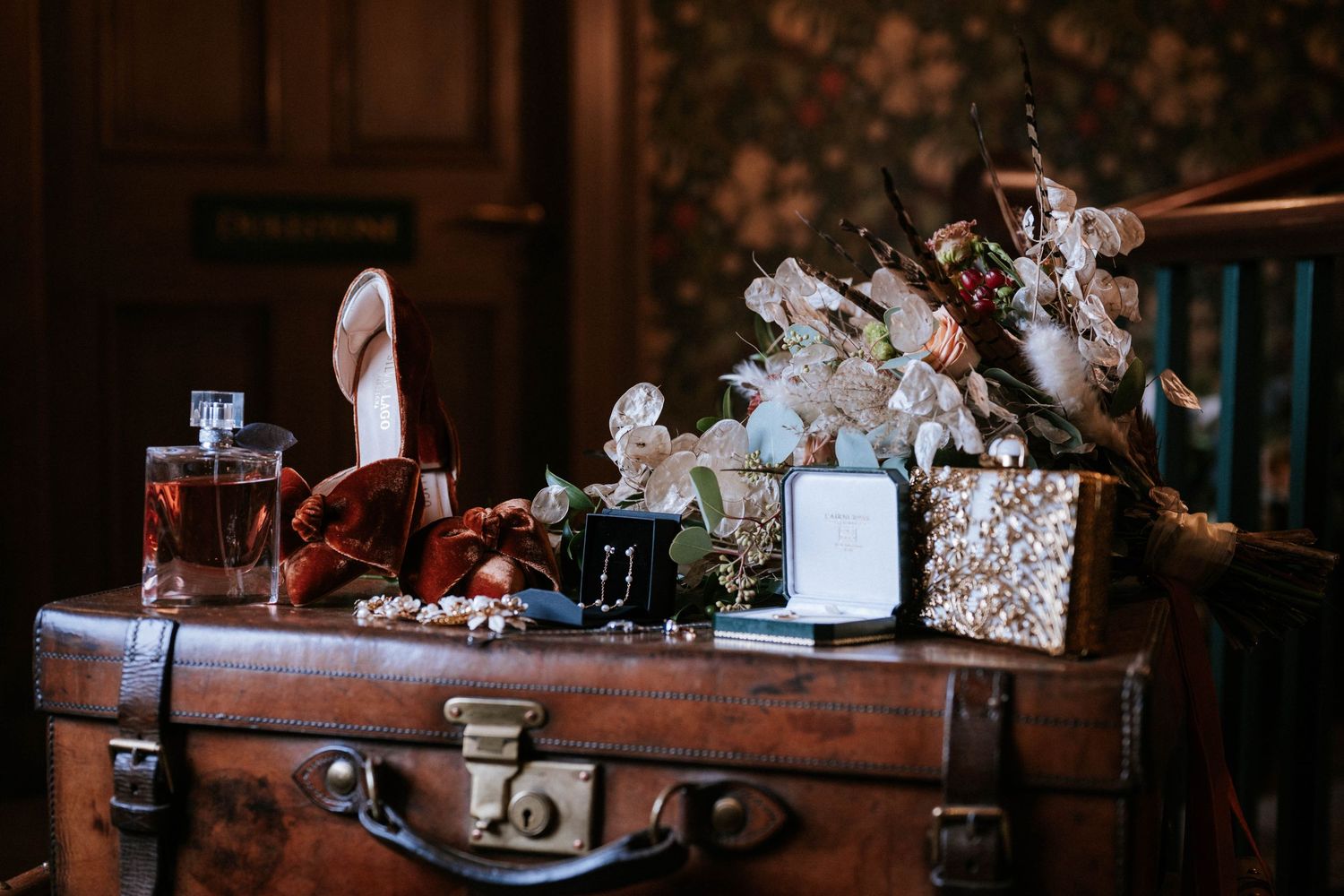Vintage suitcases and antique decor items arranged on rustic wooden furniture in warm lighting.