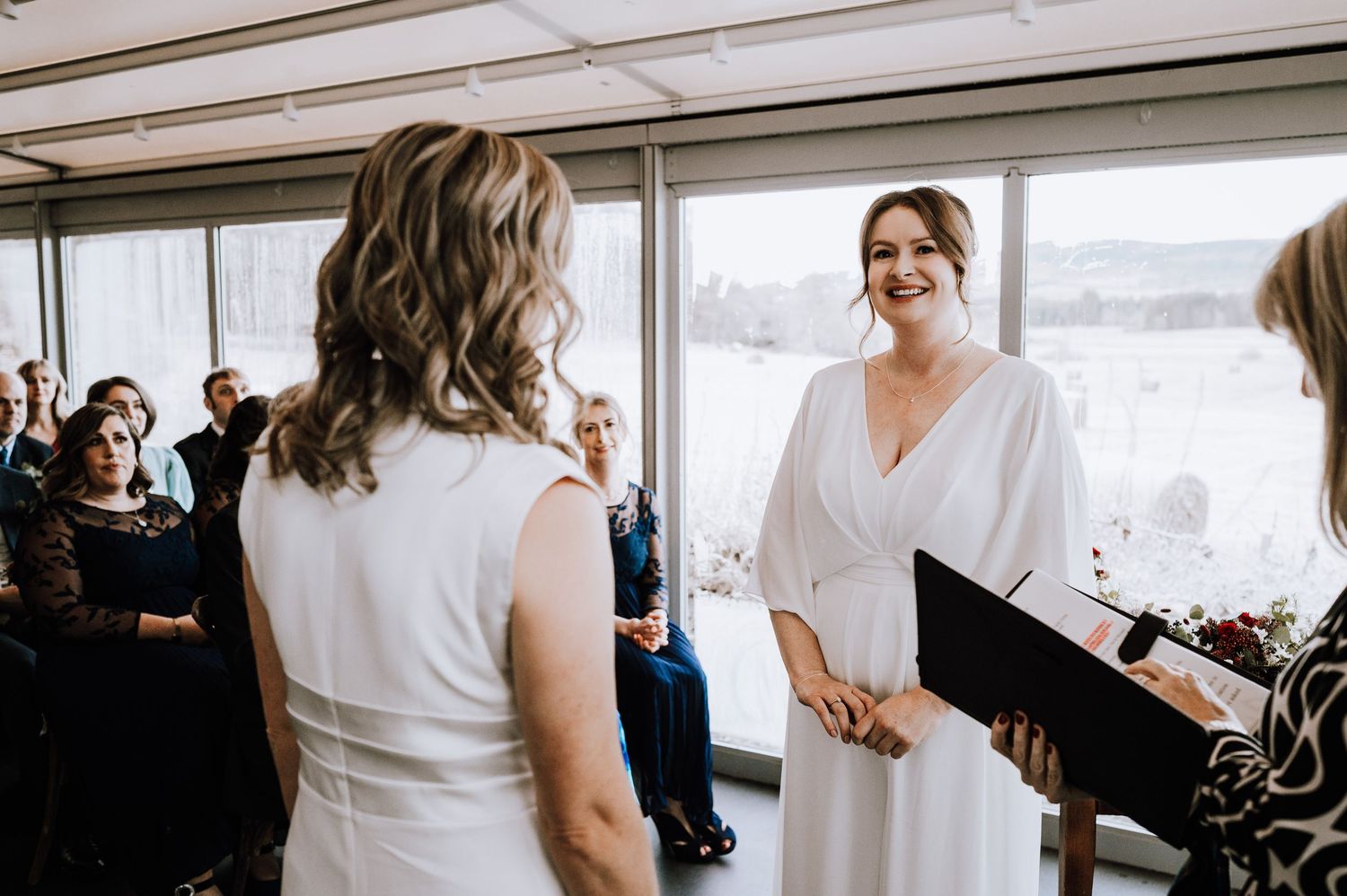 Same Sex Wedding Photography. Bright indoor wedding venue with large windows and natural light.