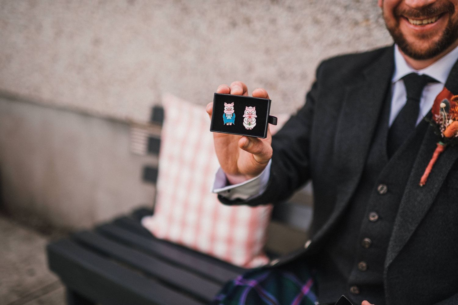 Close-up shot of hands holding small box while wearing formal attire.