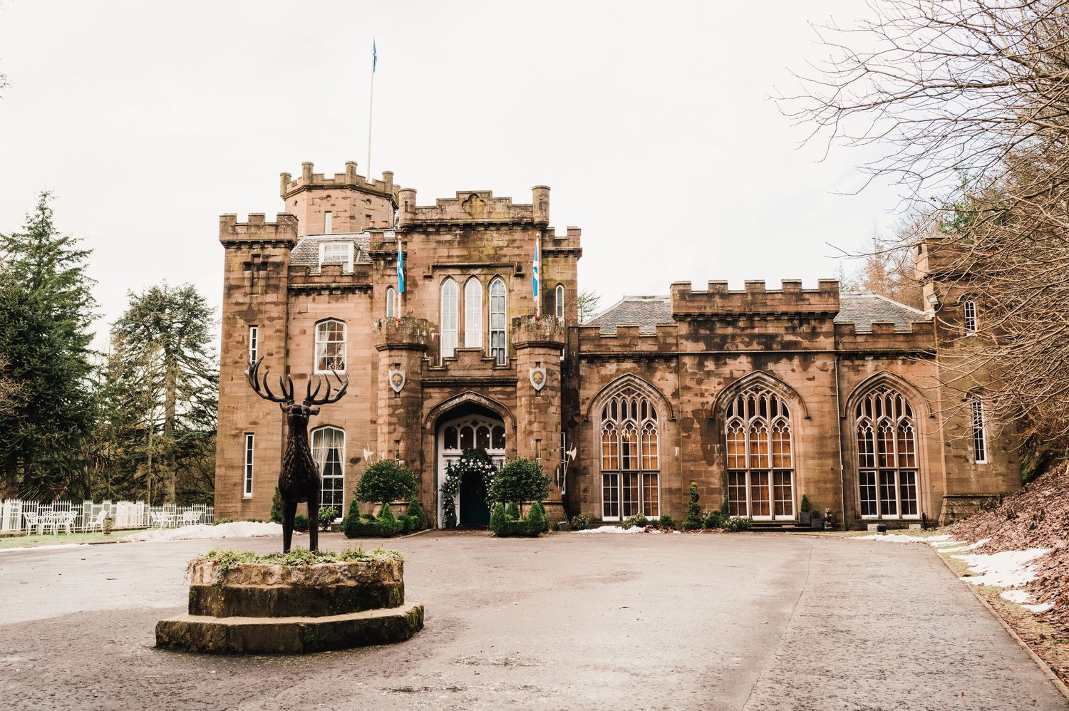 Gothic revival castle entrance with stone facade and decorative arched windows.