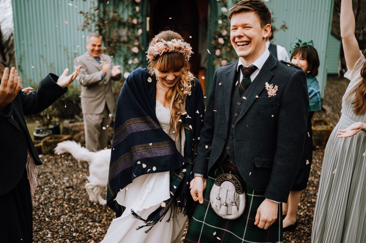 Wedding couple share a joyful moment during outdoor confetti celebration.