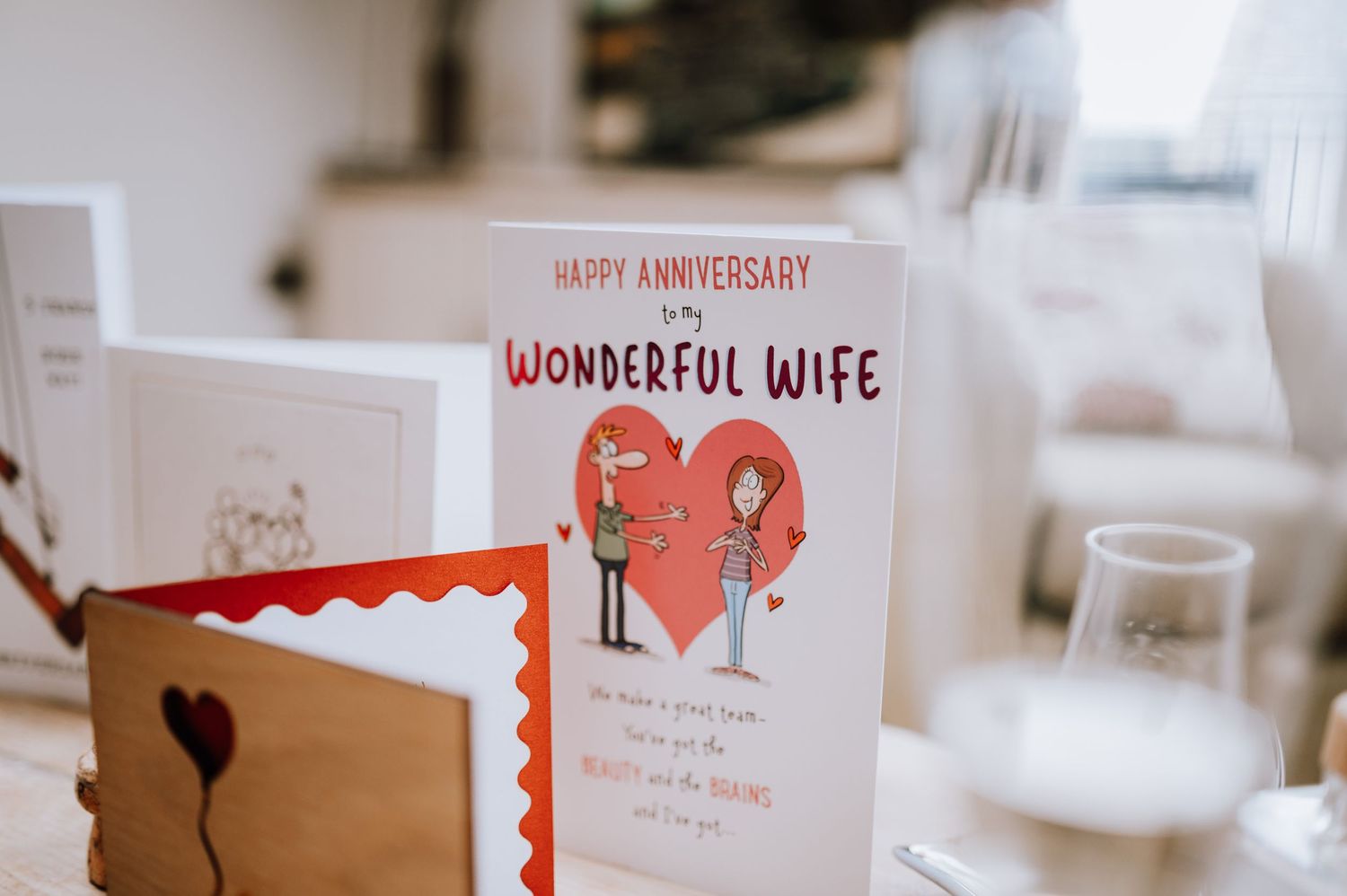 Anniversary card for wife with heart illustrations displayed on table.