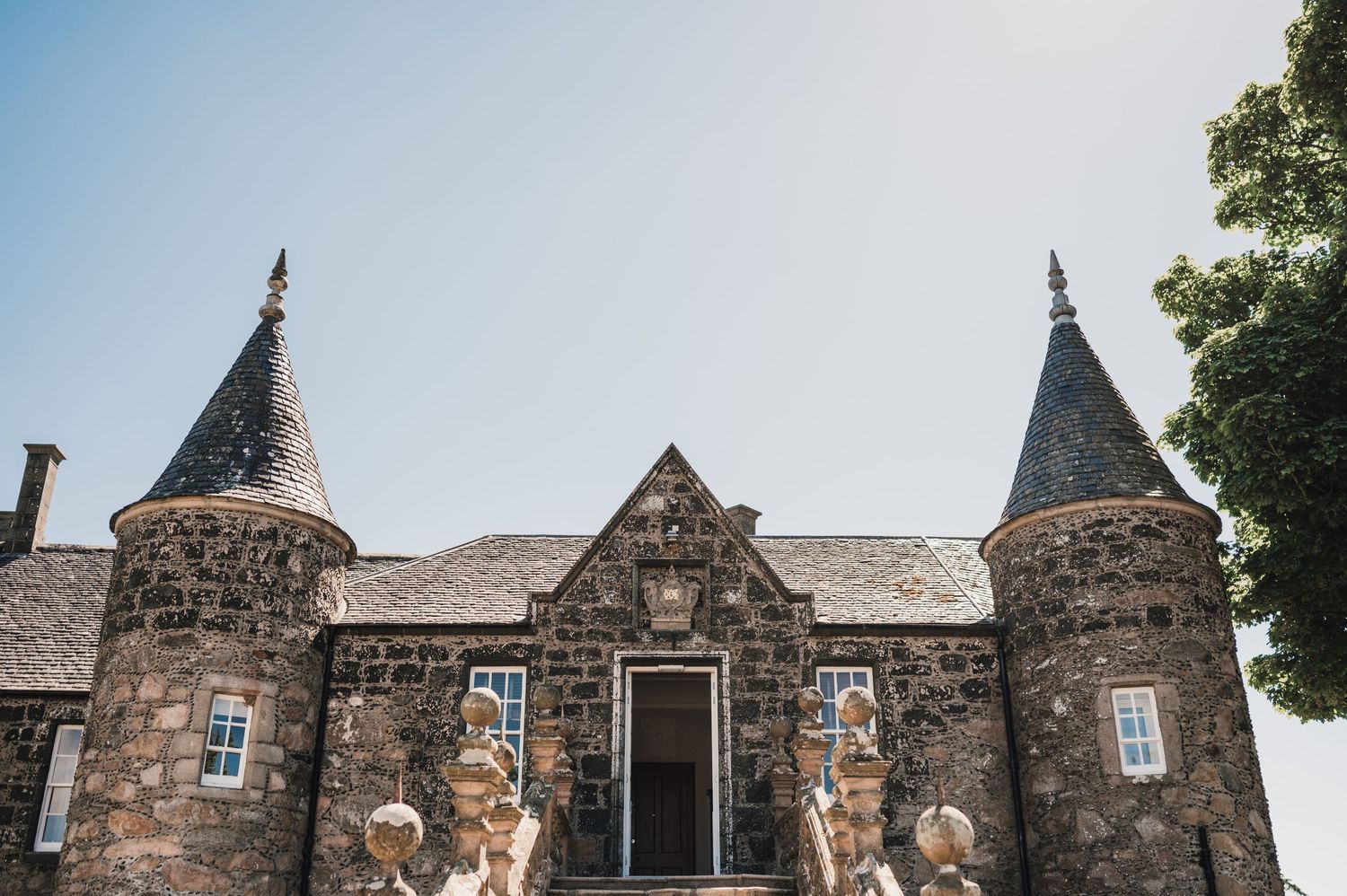 A Scottish castle-style stone building with turrets and ornate architectural details.