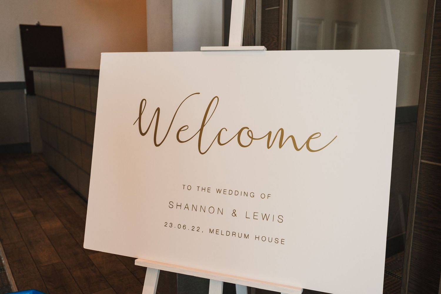An elegant welcome sign for Shannon and Lewis's wedding displayed on a white easel.