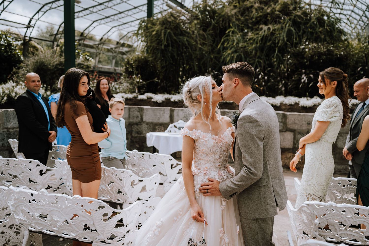 Newlyweds share an intimate moment during their greenhouse wedding reception.