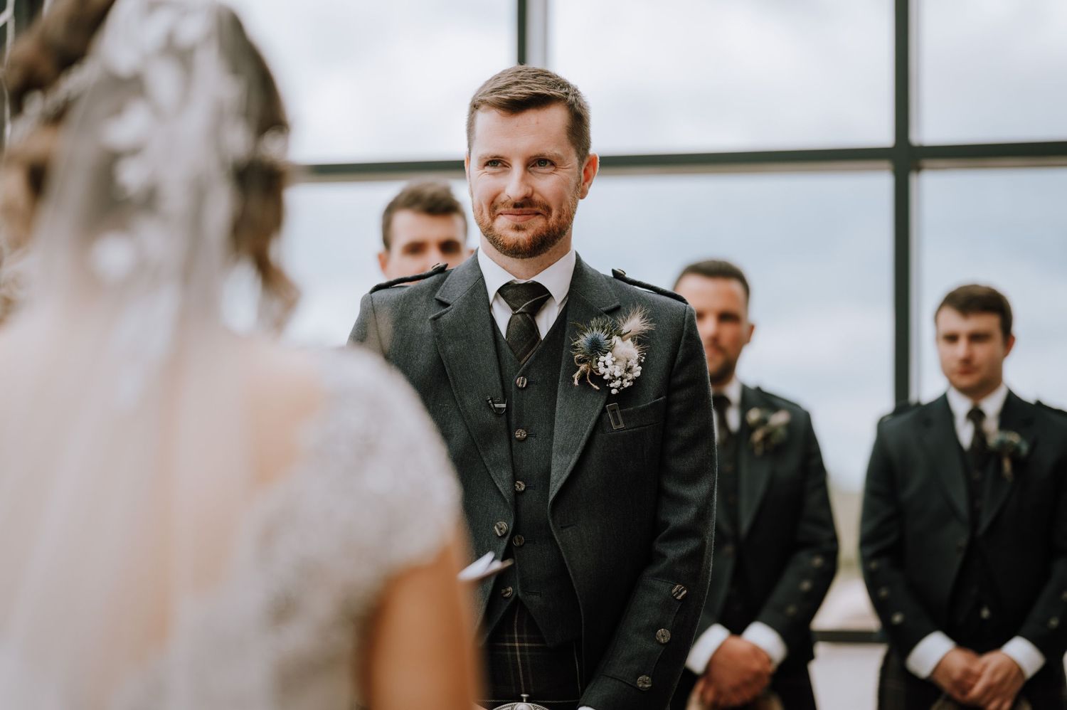 Scottish wedding celebration with groom wearing traditional kilt during indoor ceremony.