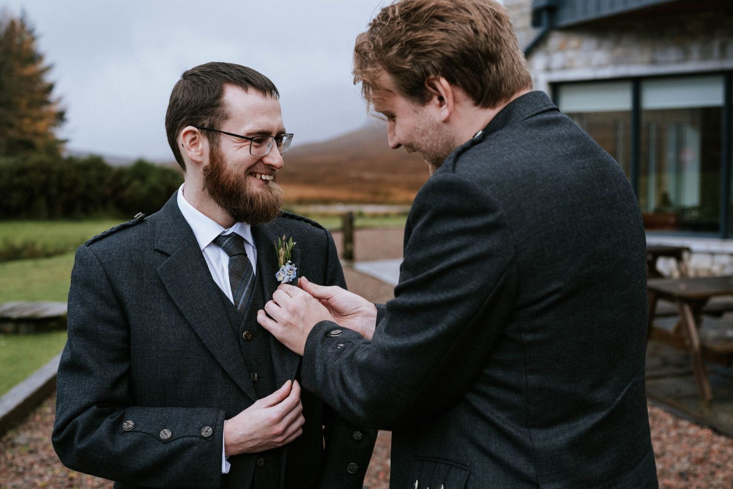 Two people in formal attire sharing a moment during a wedding ceremony outdoors.