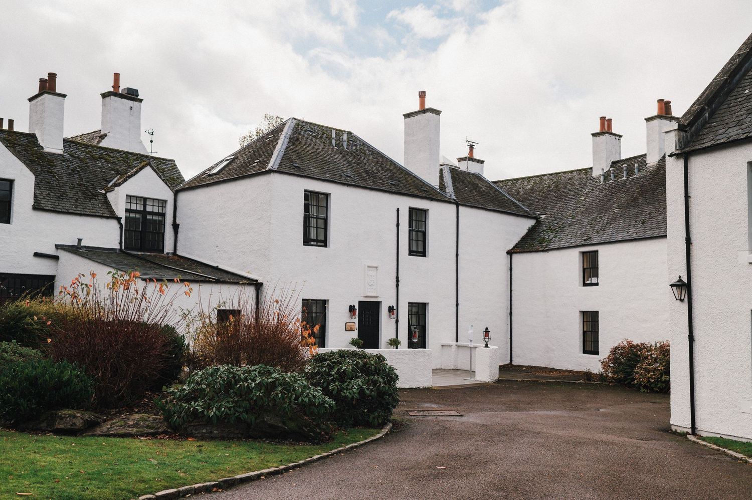 Traditional white Scottish cottages with multiple chimneys and rustic architecture.