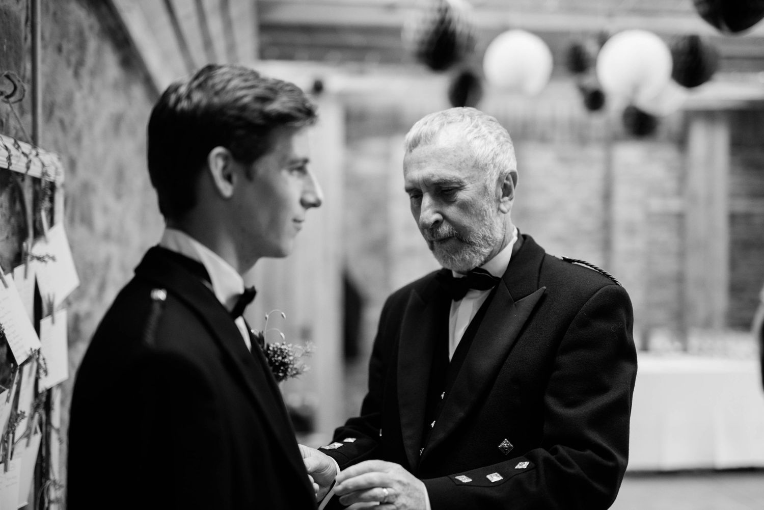 Black and white image showing an intimate conversation at a formal gathering.