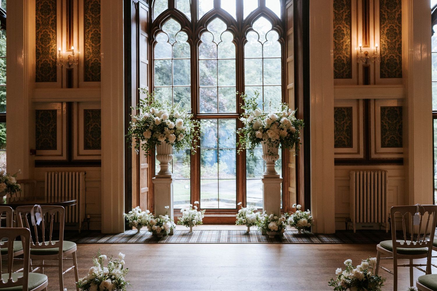 Gothic windows and warm lighting create ambiance in historic wedding venue.