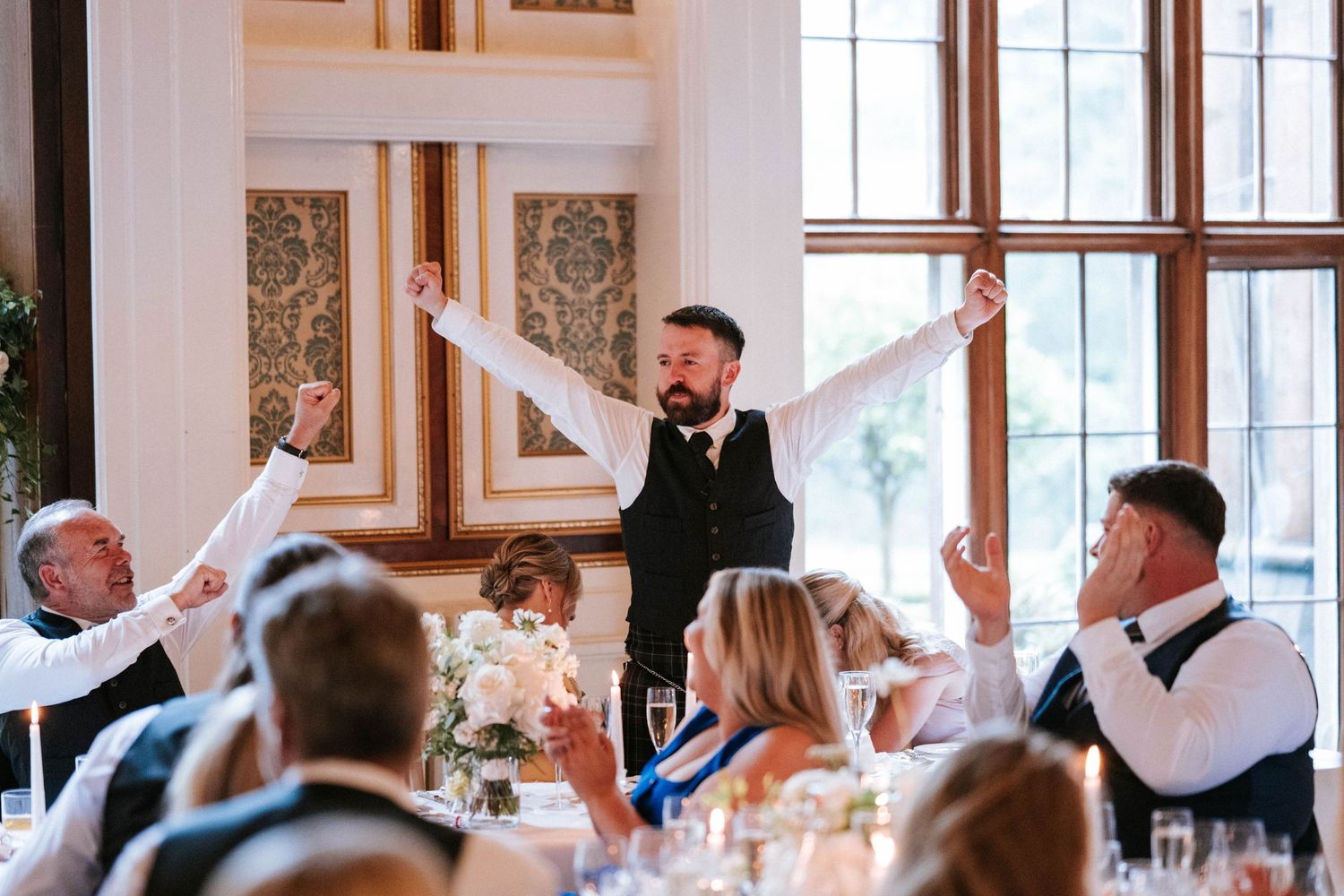 Elegant wedding reception venue with guests dancing and celebrating.