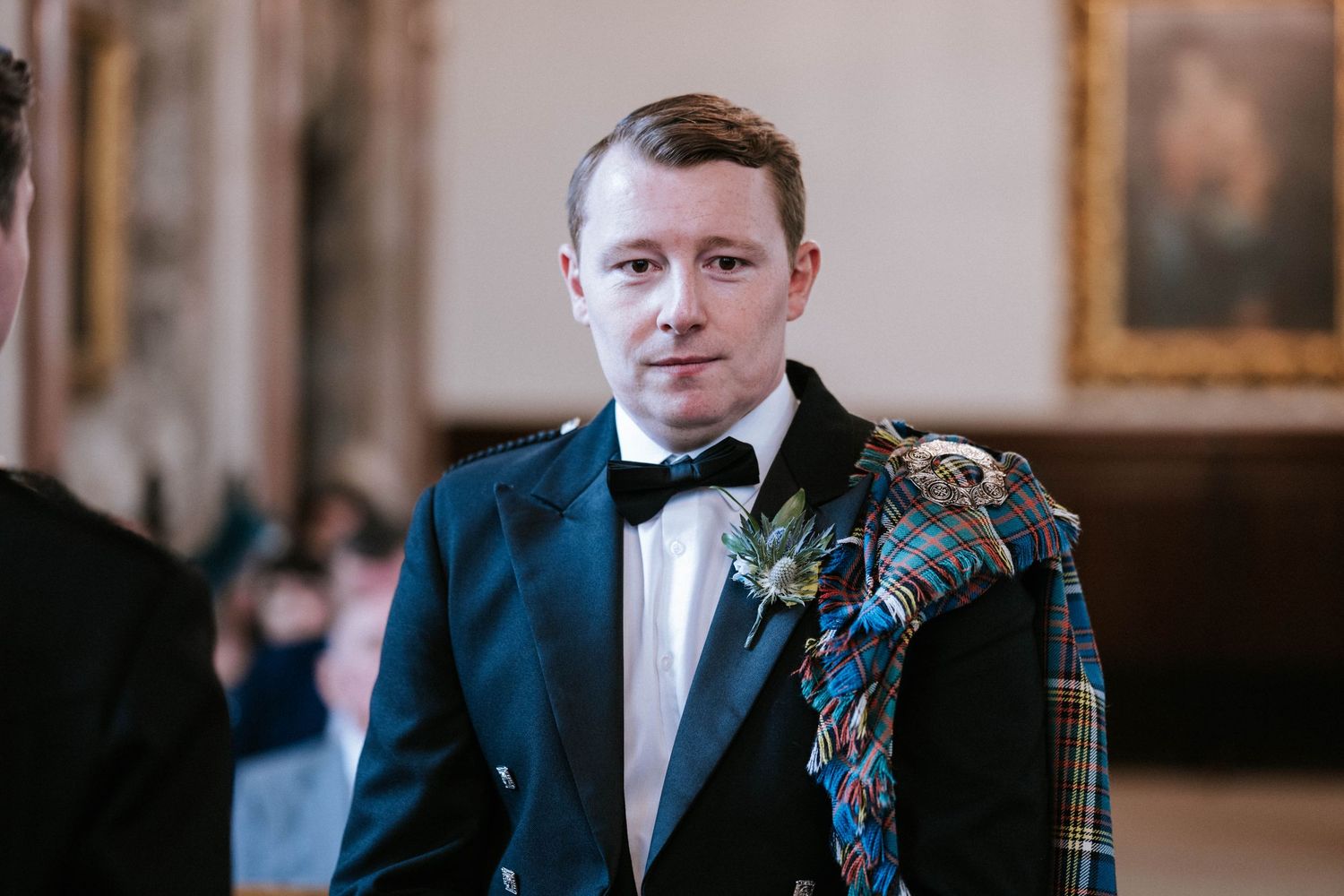 Groomsmen in formal attire with traditional Scottish kilts at wedding ceremony.