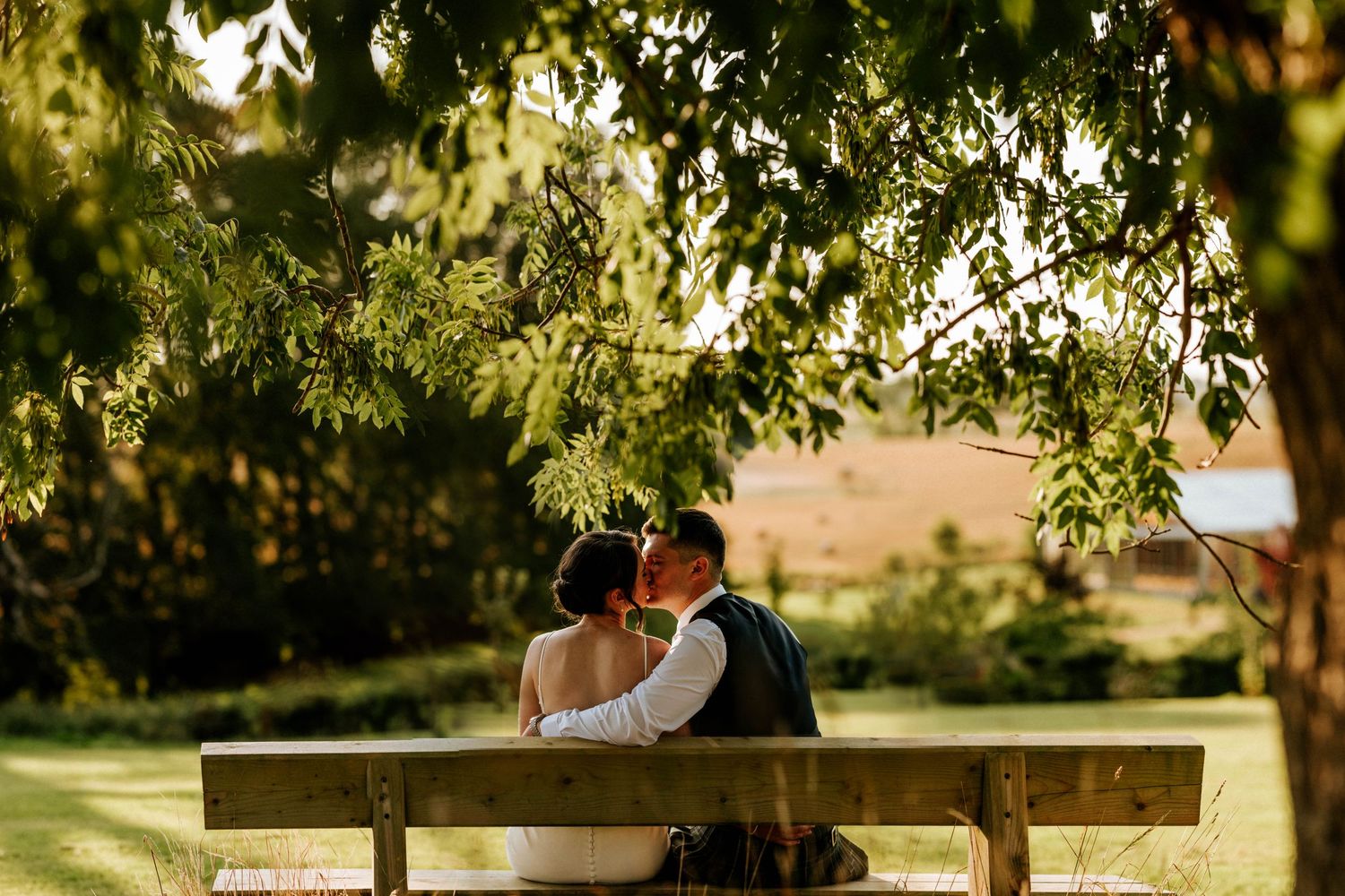 Aberdeen Wedding Photography. Wedding couple shares intimate moment under green trees in natural setting.