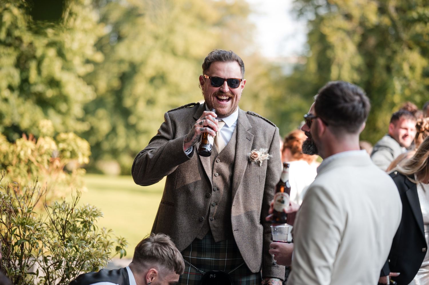 Aberdeen Wedding Photography. Wedding guests enjoying drinks and conversation during an outdoor reception.