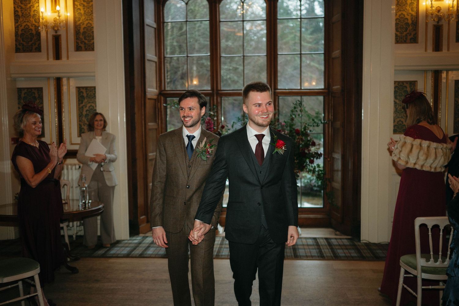 Drumtochty Castle  Wedding Photography. Elegant ballroom with warm lighting and large windows overlooking winter scenery.