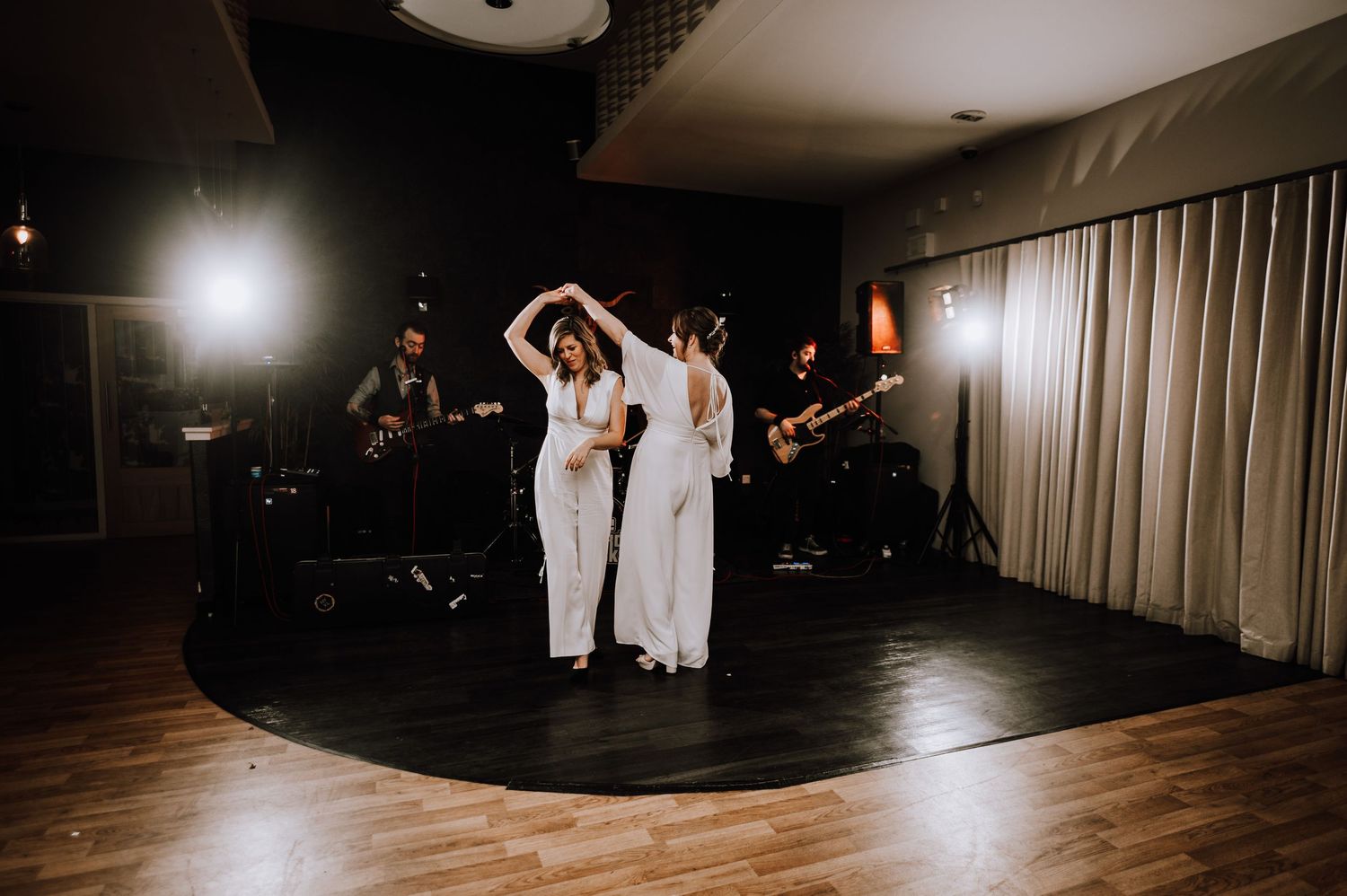 Same Sex Wedding Photography. Couples dance on a dimly lit wooden dance floor during an evening wedding reception.