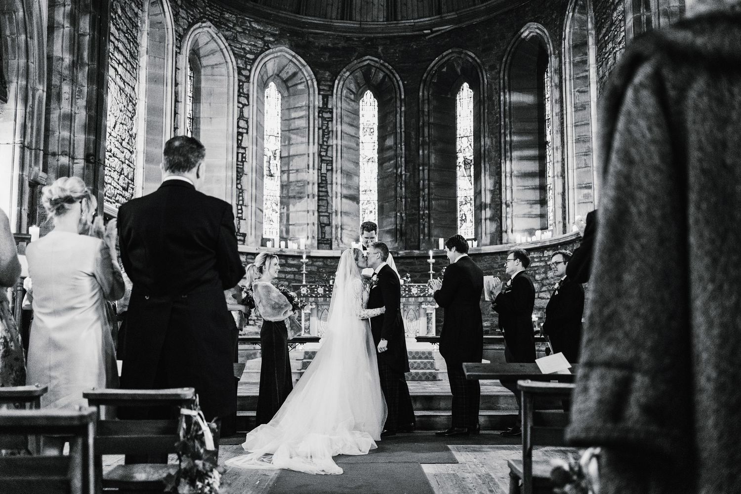 Aberdeen Wedding Photography. Wedding ceremony in progress inside a grand gothic church with vaulted ceilings.