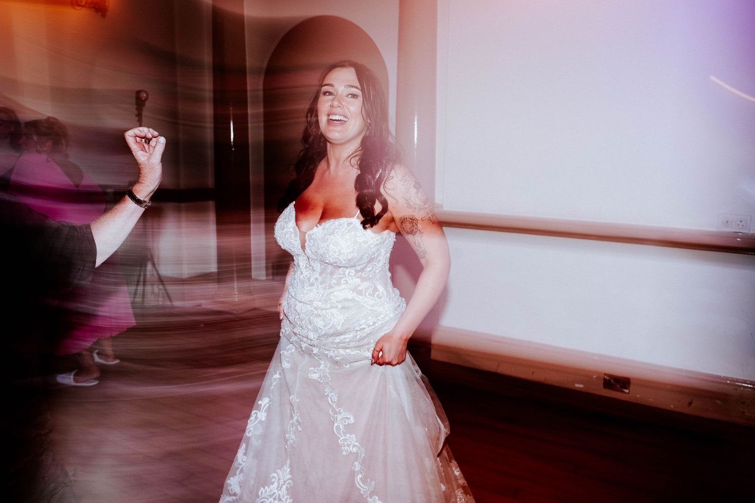 Aberdeen Wedding Photography. Dancing figures in white dresses create motion blur under purple lighting.